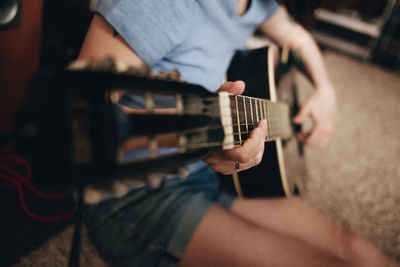 Midsection of woman playing guitar