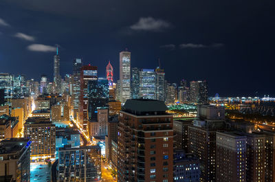 Illuminated buildings in city against sky at night