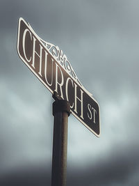 Low angle view of road sign against sky