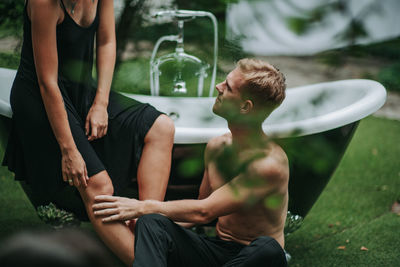 Midsection of men sitting outdoors