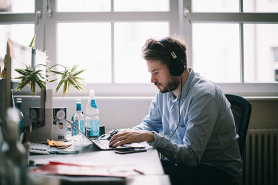 Man using laptop on table at office