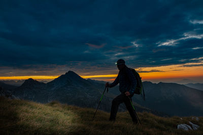 Woman on mountain against sky during sunset