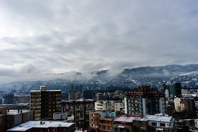 High angle view of cityscape against cloudy sky