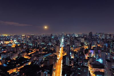 High angle view of illuminated cityscape against sky at night
