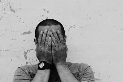 Man covering his face