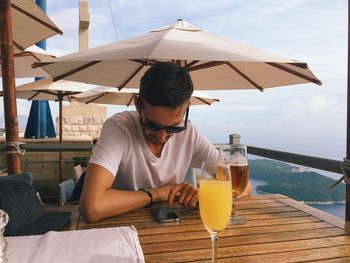 Young man using mobile on table at restaurant