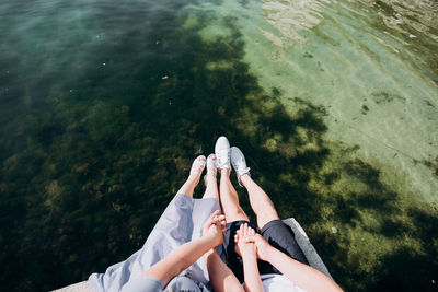 High angle view of people hands in water