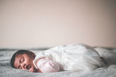 Cute baby girl sleeping on bed at home