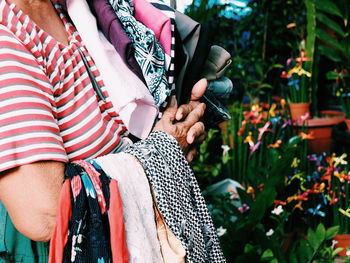 Side view of a old woman holding textiles 
